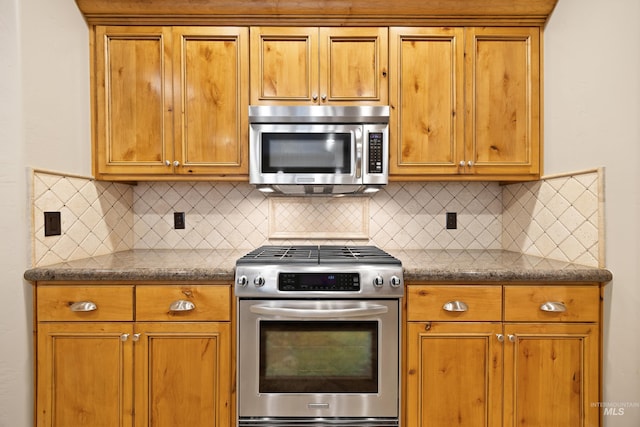 kitchen featuring decorative backsplash, dark countertops, brown cabinets, and stainless steel appliances