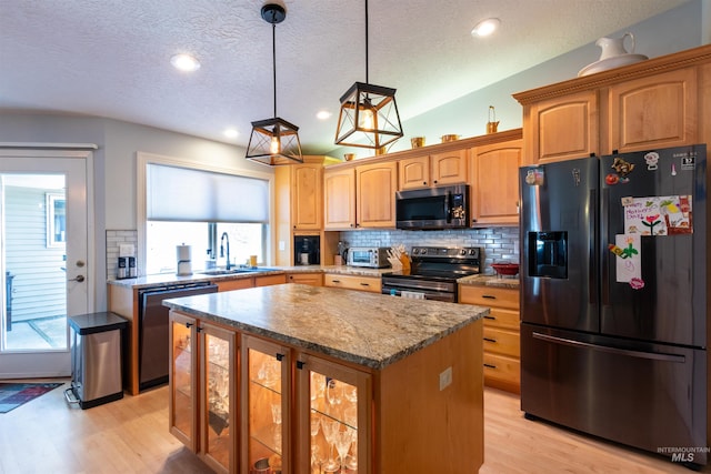 4023 N Bayou Ln, Boise, ID 83703 - kitchen with stainless steel appliances, a sink, light wood finished floors, a kitchen island, and decorative backsplash