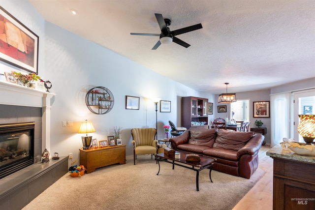 4023 N Bayou Ln, Boise, ID 83703 - living area featuring a tiled fireplace, a ceiling fan, a chandelier, and a textured ceiling