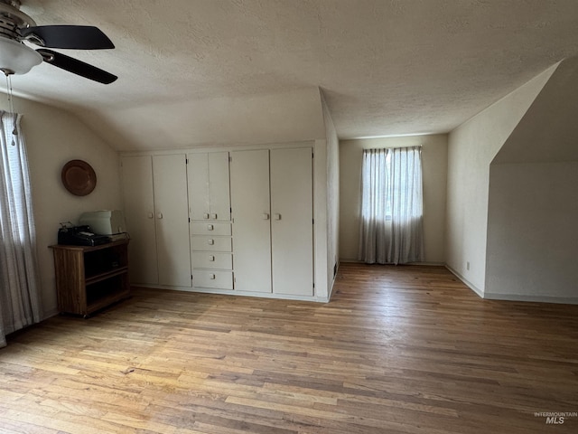 7119 W Everett, Boise, ID 83704 - additional living space with light wood-style flooring, a textured ceiling, vaulted ceiling, a ceiling fan, and baseboards