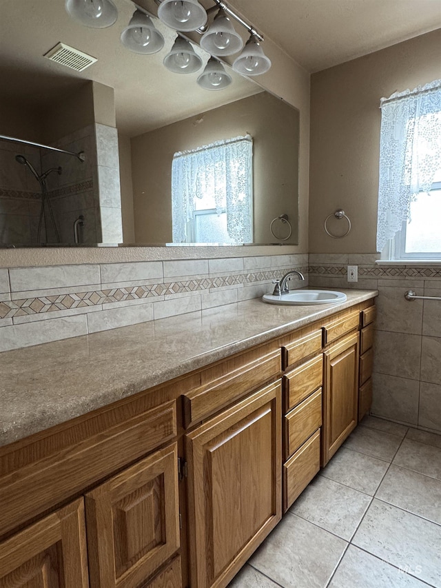 7119 W Everett, Boise, ID 83704 - bathroom featuring tile walls, a tile shower, tile patterned flooring, double vanity, and a wainscoted wall