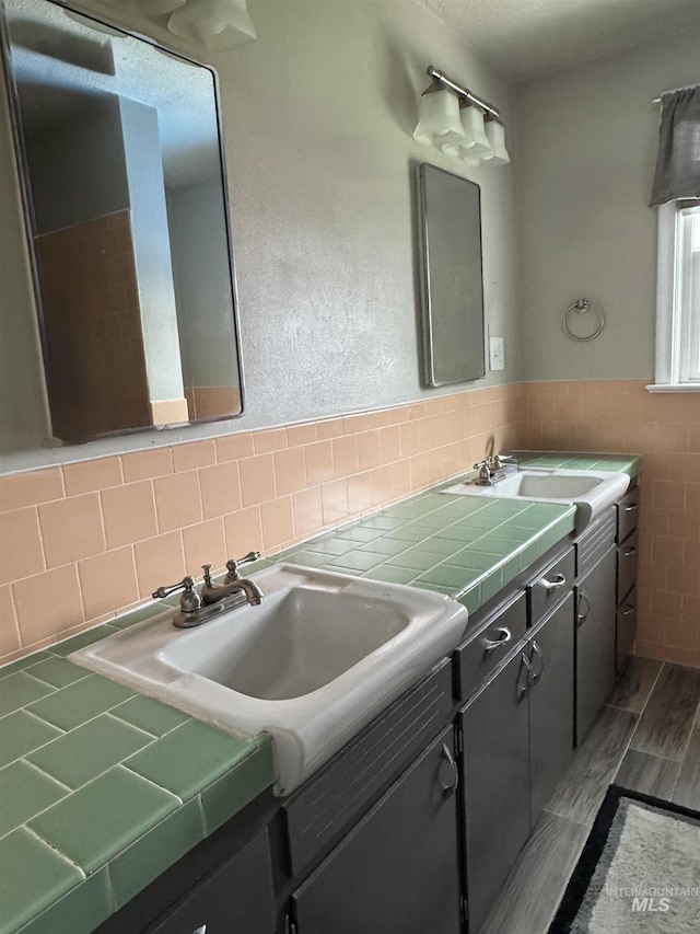 7119 W Everett, Boise, ID 83704 - bathroom featuring tile walls, double vanity, wainscoting, and wood finished floors