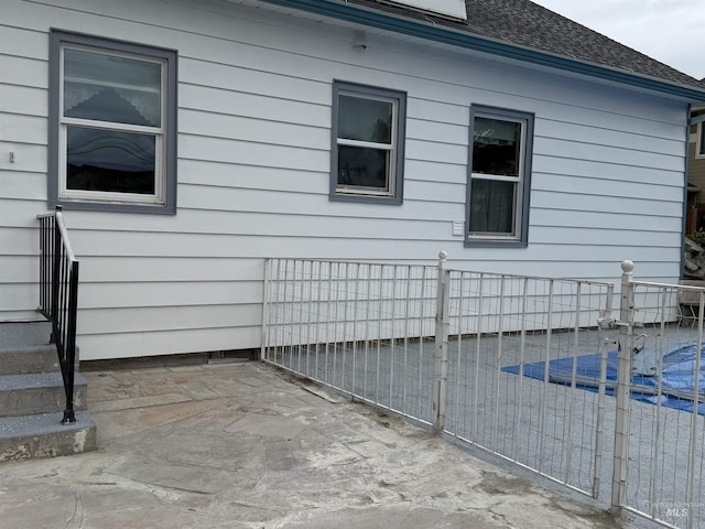 7119 W Everett, Boise, ID 83704 - view of property exterior with a pool, a shingled roof, a patio area, and fence