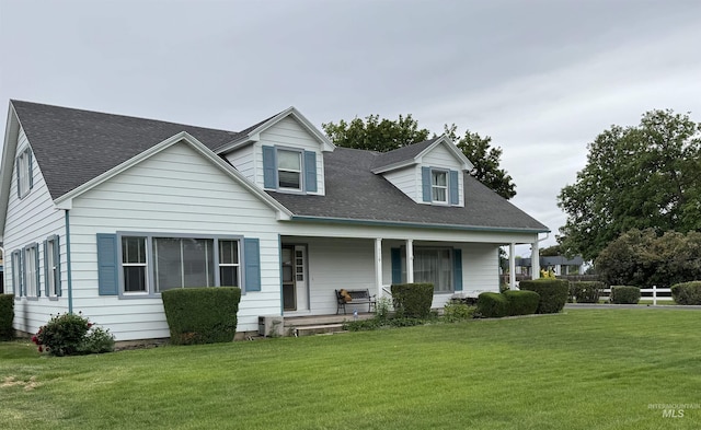 7119 W Everett, Boise, ID 83704 - cape cod house featuring covered porch, a front lawn, and a shingled roof