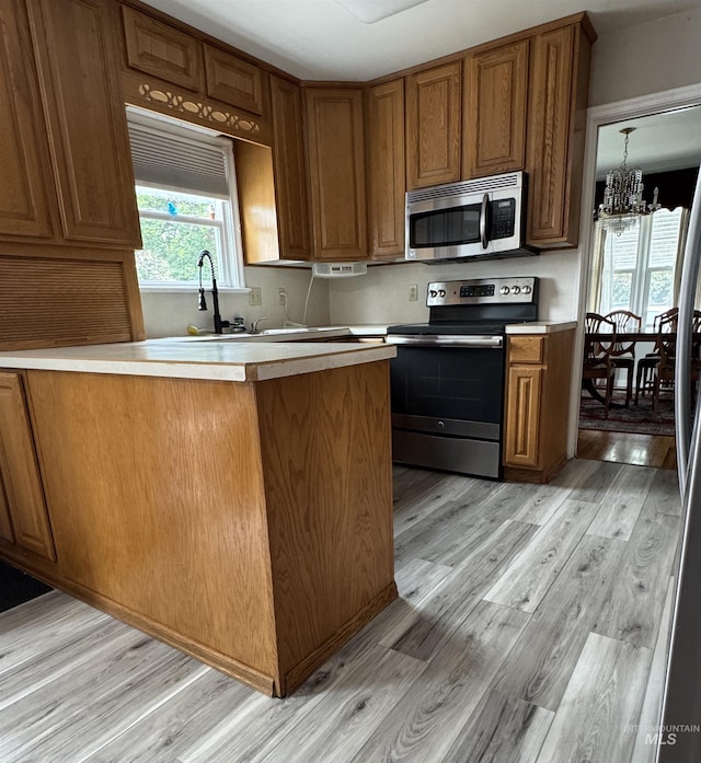 7119 W Everett, Boise, ID 83704 - kitchen featuring appliances with stainless steel finishes, brown cabinetry, light countertops, and light wood finished floors