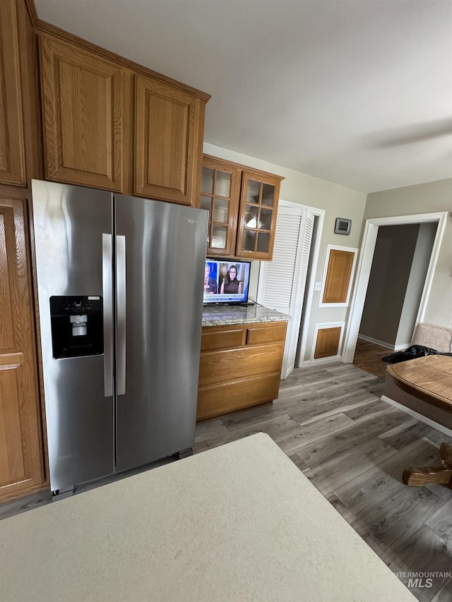 7119 W Everett, Boise, ID 83704 - kitchen with stainless steel fridge, brown cabinets, baseboards, and wood finished floors