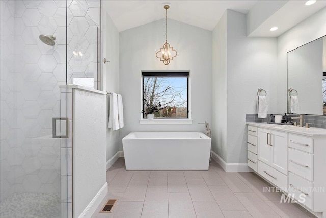 full bathroom with visible vents, a freestanding bath, vaulted ceiling, a stall shower, and vanity