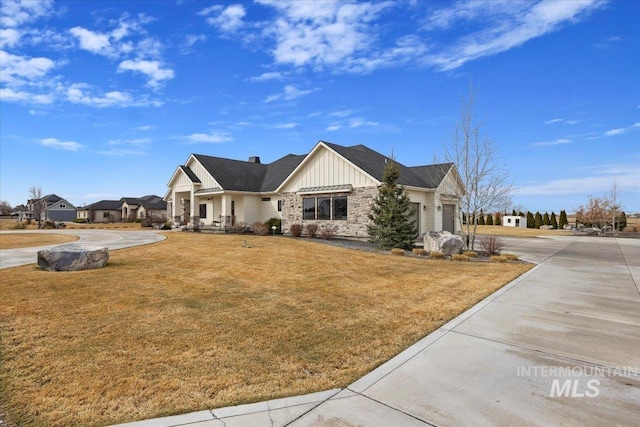 view of front of property with a garage, board and batten siding, concrete driveway, and a front yard