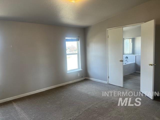 unfurnished bedroom with carpet, baseboards, and a textured ceiling