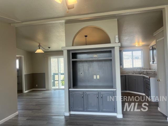 kitchen with a wealth of natural light, dark wood finished floors, baseboards, and a sink