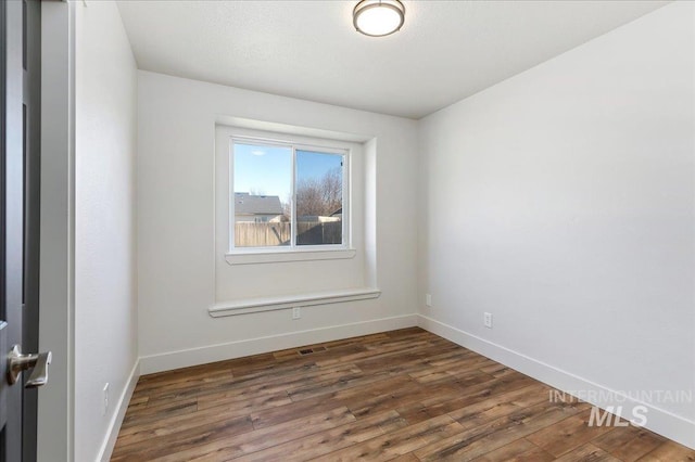 empty room featuring dark hardwood / wood-style flooring