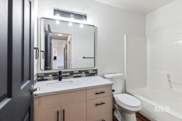 full bathroom featuring toilet, vanity, tasteful backsplash, and washtub / shower combination