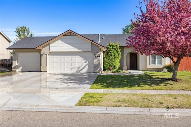 view of front of house featuring an attached garage, a front lawn, roof with shingles, and concrete driveway