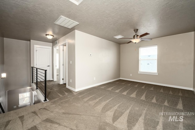 carpeted spare room with ceiling fan and a textured ceiling