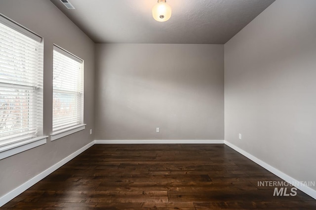 empty room with dark wood-type flooring