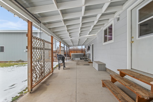 view of patio featuring entry steps, a hot tub, fence, and a grill