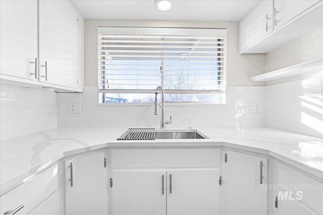 kitchen with white cabinetry, sink, and decorative backsplash