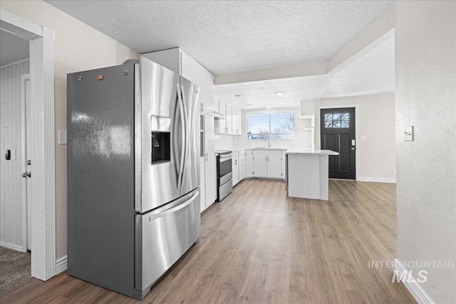 kitchen with sink, white cabinets, stainless steel appliances, a textured ceiling, and light hardwood / wood-style flooring