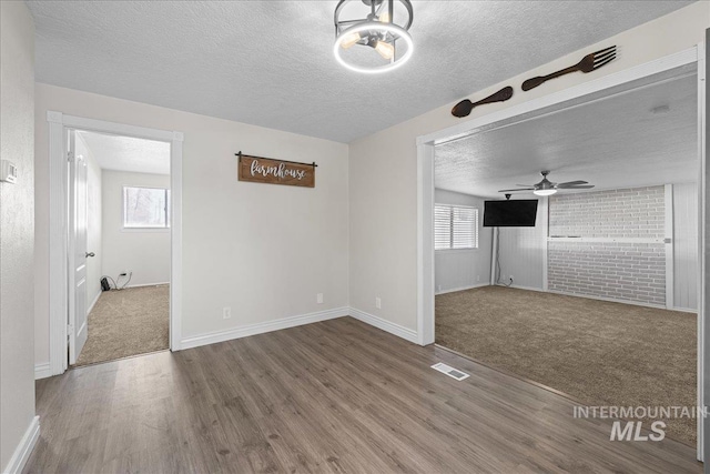 empty room featuring hardwood / wood-style flooring, a healthy amount of sunlight, and a textured ceiling