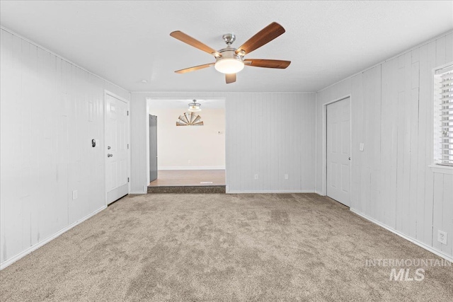 unfurnished room with ceiling fan and carpet