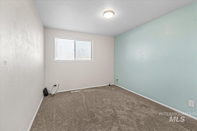 carpeted spare room with a textured ceiling