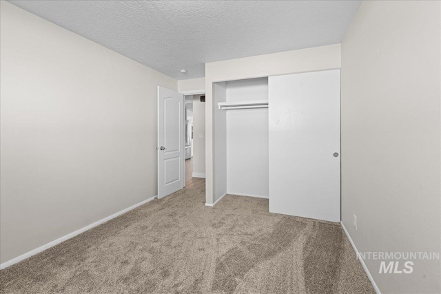 unfurnished bedroom featuring a closet, carpet flooring, and a textured ceiling