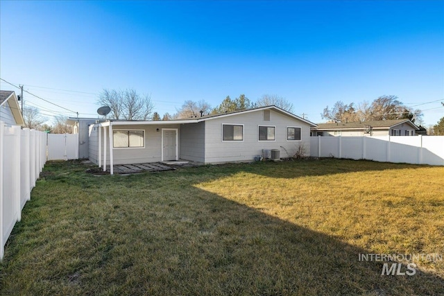 rear view of house with a yard and central air condition unit