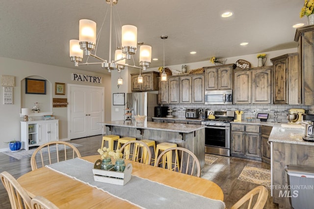 dining area featuring baseboards, dark wood finished floors, a chandelier, recessed lighting, and a textured ceiling