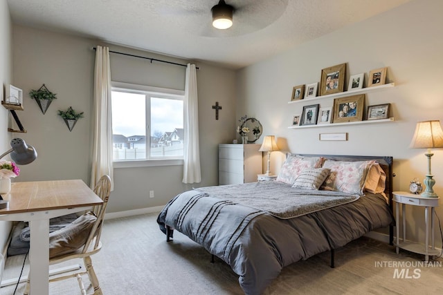 bedroom featuring ceiling fan, a textured ceiling, baseboards, and carpet floors