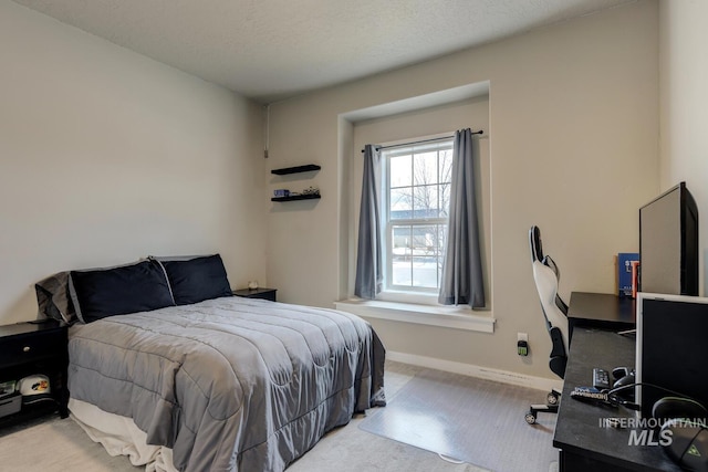 bedroom with baseboards, carpet, and a textured ceiling