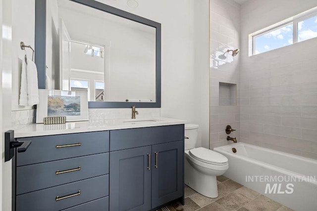 full bathroom featuring vanity, tiled shower / bath combo, and toilet