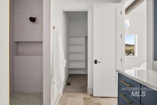 bathroom featuring vanity, lofted ceiling with beams, and walk in shower