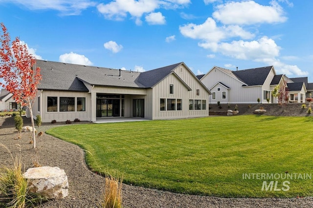 rear view of house featuring a lawn and a patio