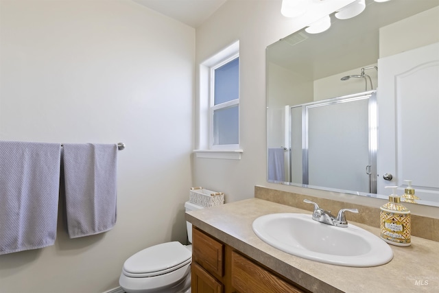 bathroom featuring vanity, toilet, and an enclosed shower