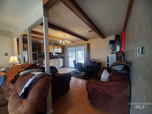 living room with beam ceiling, hardwood / wood-style floors, and a notable chandelier