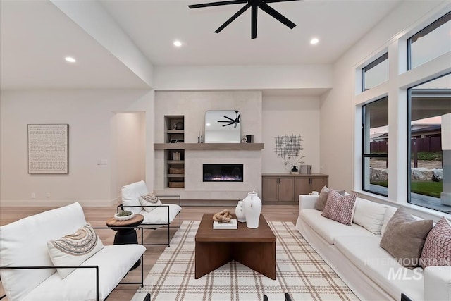 9989 W Bouvardia St, Star, ID 83699 - living room featuring ceiling fan, light wood-type flooring, recessed lighting, a fireplace, and built in features