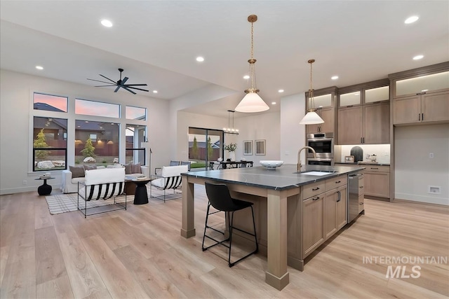 9989 W Bouvardia St, Star, ID 83699 - kitchen with a sink, an island with sink, light wood-style flooring, recessed lighting, and a kitchen breakfast bar