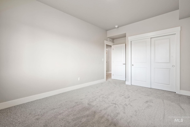 unfurnished bedroom with a closet, carpet flooring, and baseboards