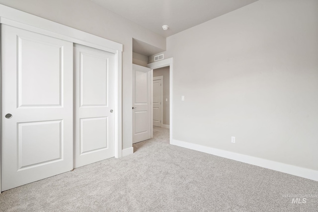 unfurnished bedroom featuring visible vents, carpet, a closet, and baseboards