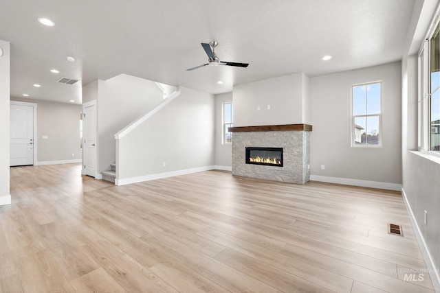 unfurnished living room featuring stairs, a healthy amount of sunlight, and visible vents