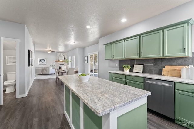 kitchen featuring dark wood-style flooring, green cabinetry, a kitchen island, and stainless steel dishwasher