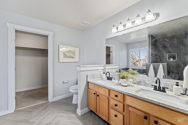 bathroom with visible vents, a sink, a textured ceiling, and toilet