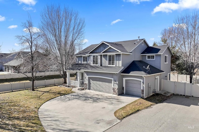 traditional-style house featuring a garage, concrete driveway, fence, and a shingled roof