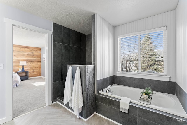 ensuite bathroom featuring a garden tub, ensuite bath, a tile shower, and a textured ceiling