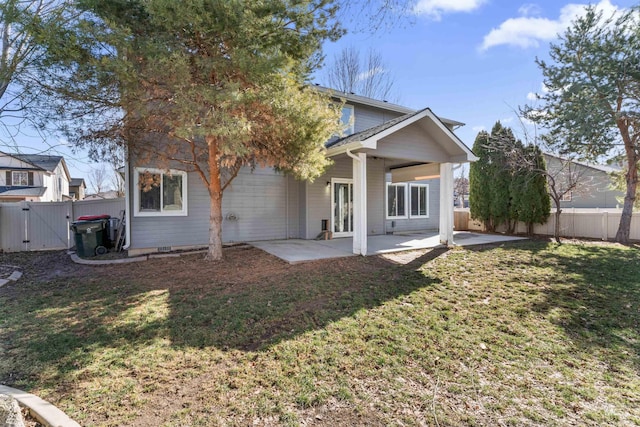 rear view of property with a patio, a lawn, a fenced backyard, and a gate