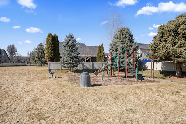 community jungle gym with a lawn and fence