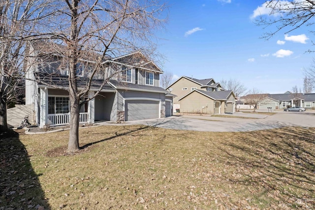 view of yard featuring covered porch, concrete driveway, an attached garage, and a residential view