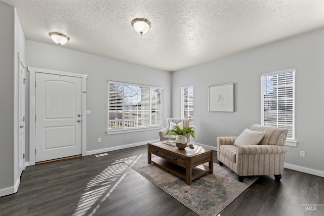 sitting room with a textured ceiling, dark wood finished floors, and baseboards