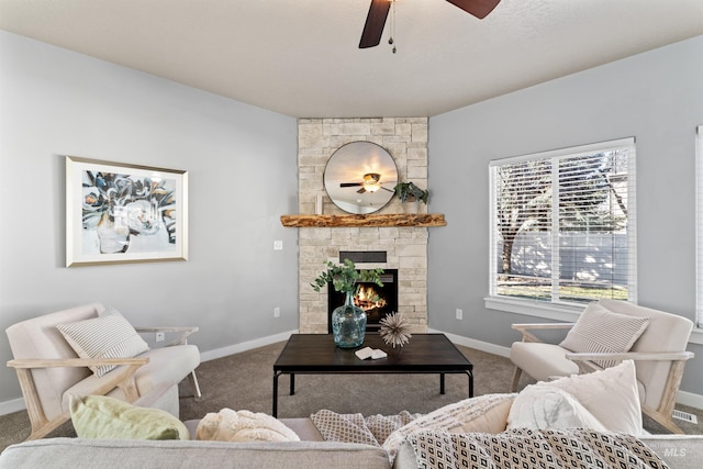 living room featuring a ceiling fan, carpet, a fireplace, and baseboards