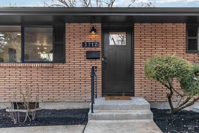 doorway to property featuring brick siding